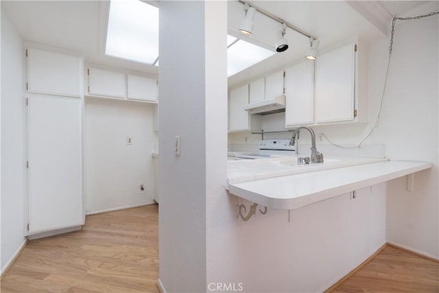 6523 E Camino Unit 2, Anaheim, CA 92807 - kitchen with white electric range, light wood-style floors, under cabinet range hood, and white cabinetry