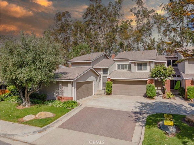 6523 E Camino Unit 2, Anaheim, CA 92807 - view of front of house with decorative driveway, a garage, a shingled roof, and stucco siding