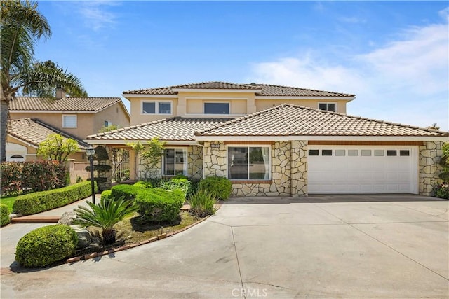 18560 Stonegate Ln, Rowland Heights, CA 91748 - mediterranean / spanish-style house featuring stone siding, a garage, concrete driveway, a tiled roof, and stucco siding