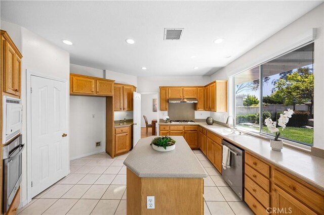 18560 Stonegate Ln, Rowland Heights, CA 91748 - kitchen featuring stainless steel appliances, a sink, a kitchen island, brown cabinets, and light tile patterned flooring