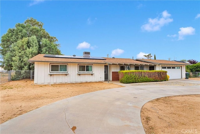 21046 Lone Eagle Rd, Apple Valley, CA 92308 - single story home with fence, roof mounted solar panels, driveway, an attached garage, and board and batten siding