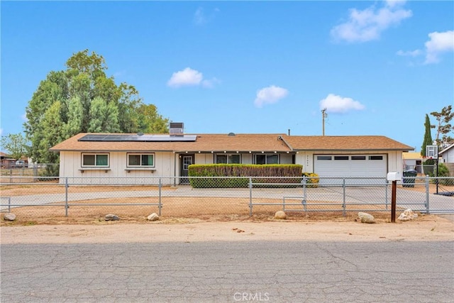 21046 Lone Eagle Rd, Apple Valley, CA 92308 - ranch-style home with an attached garage, a fenced front yard, solar panels, driveway, and board and batten siding