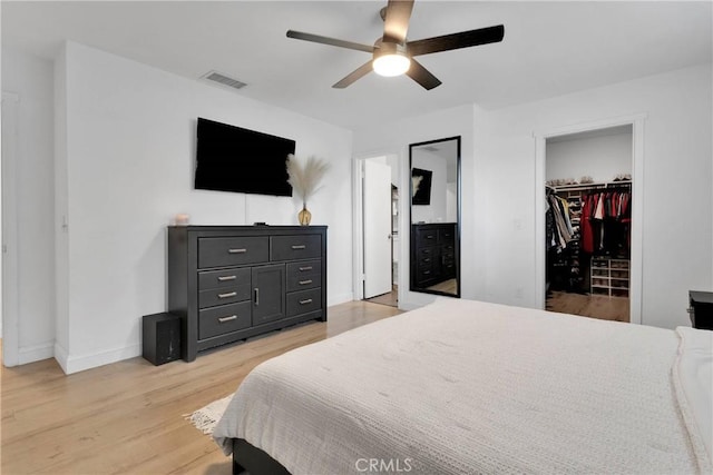 21046 Lone Eagle Rd, Apple Valley, CA 92308 - bedroom featuring a walk in closet, baseboards, light wood finished floors, a closet, and a ceiling fan
