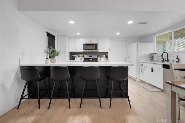 21046 Lone Eagle Rd, Apple Valley, CA 92308 - kitchen featuring appliances with stainless steel finishes, backsplash, a sink, a breakfast bar, and recessed lighting