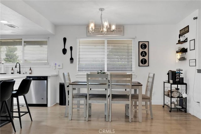 21046 Lone Eagle Rd, Apple Valley, CA 92308 - dining area featuring a chandelier, light wood-style floors, and baseboards