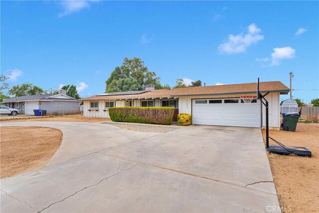 21046 Lone Eagle Rd, Apple Valley, CA 92308 - ranch-style home featuring driveway, roof mounted solar panels, an attached garage, and fence