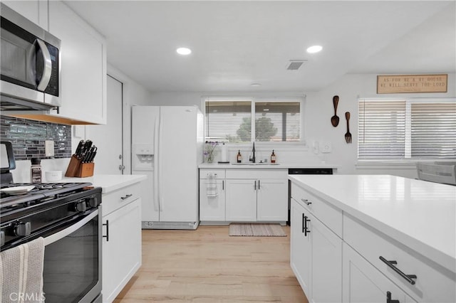 21046 Lone Eagle Rd, Apple Valley, CA 92308 - kitchen featuring stainless steel appliances, a sink, light wood-style floors, tasteful backsplash, and light countertops