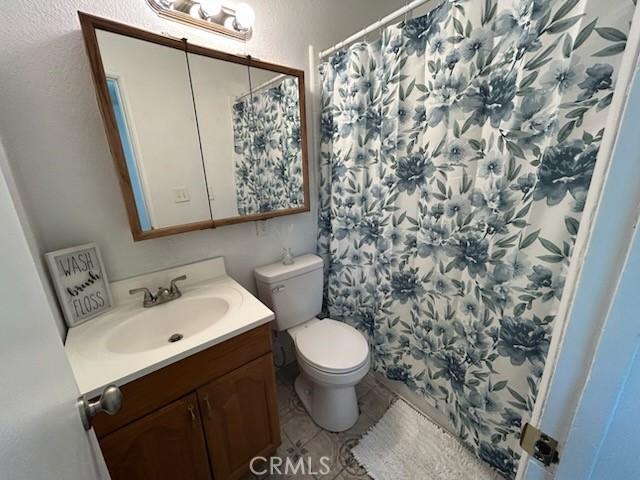 8960 Indiana Ave, Riverside, CA 92503 - full bath featuring vanity, toilet, curtained shower, and tile patterned flooring