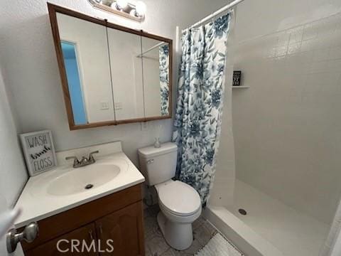 8960 Indiana Ave, Riverside, CA 92503 - bathroom with a shower stall, vanity, and toilet