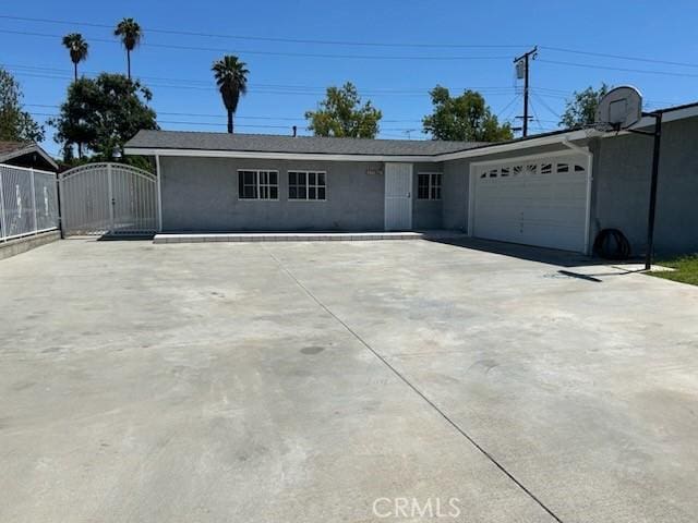 8960 Indiana Ave, Riverside, CA 92503 - ranch-style house featuring driveway, a gate, an attached garage, and stucco siding
