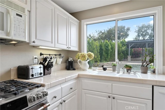 5549 Pine Ave, Chino Hills, CA 91709 - kitchen with white microwave, white cabinetry, dishwasher, stainless steel gas range, and tile countertops