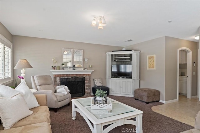 5549 Pine Ave, Chino Hills, CA 91709 - tiled living area with arched walkways, carpet floors, a brick fireplace, and baseboards
