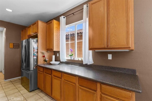 16549 Gala Ave, Fontana, CA 92337 - kitchen with freestanding refrigerator, dark countertops, and brown cabinetry