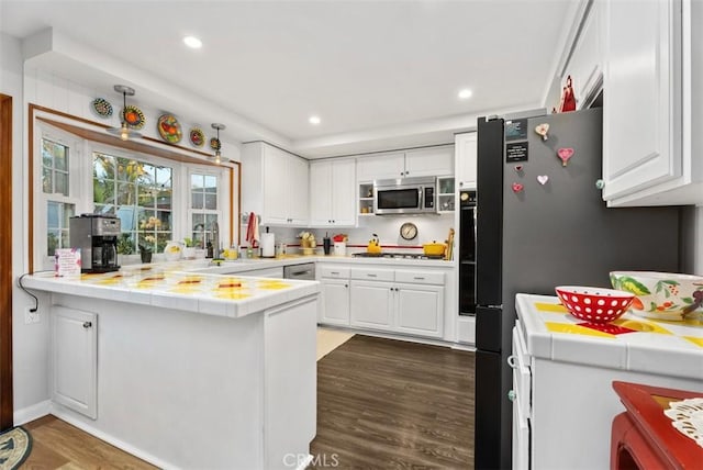 21372 Sand Dollar Ln, Huntington Beach, CA 92646 - kitchen featuring white cabinetry, tile countertops, dark wood finished floors, stainless steel appliances, and a peninsula