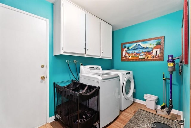 21372 Sand Dollar Ln, Huntington Beach, CA 92646 - washroom featuring cabinet space, washer and dryer, light wood-style flooring, and baseboards