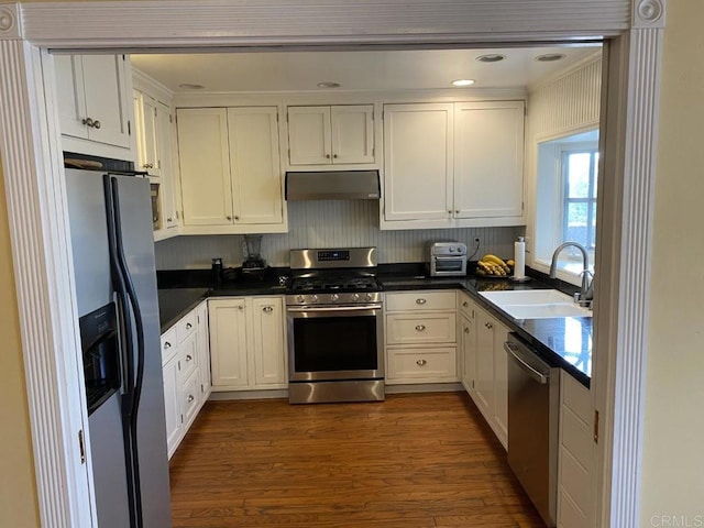 6172 Tamilynn St, San Diego, CA 92122 - kitchen featuring appliances with stainless steel finishes, a sink, under cabinet range hood, dark countertops, and white cabinetry