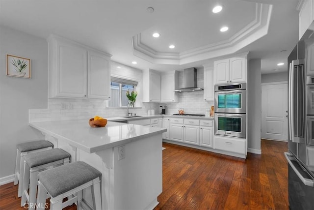 1817 Clark Ln Unit B, Redondo Beach, CA 90278 - kitchen with wall chimney exhaust hood, appliances with stainless steel finishes, a breakfast bar, white cabinets, and recessed lighting