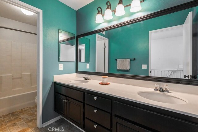 5354 Wrangler Dr, Fontana, CA 92336 - bathroom featuring stone finish flooring, double vanity, and shower / washtub combination