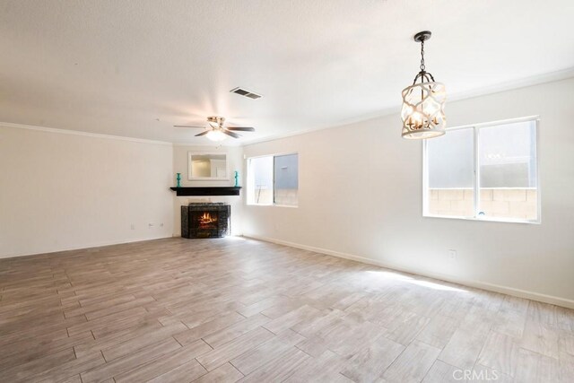 5354 Wrangler Dr, Fontana, CA 92336 - unfurnished living room with plenty of natural light, wood finished floors, a chandelier, a warm lit fireplace, and ornamental molding