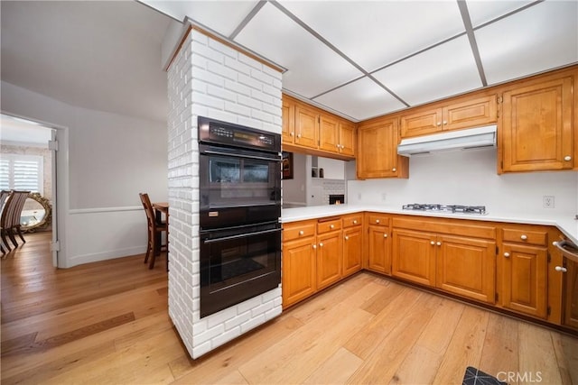 780 Brown Sage Dr, Glendora, CA 91741 - kitchen with gas cooktop, light wood-type flooring, under cabinet range hood, light countertops, and brown cabinetry
