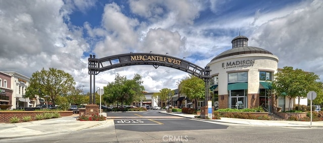 view of asphalt road featuring sidewalks, traffic signs, and curbs
