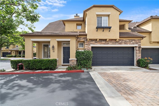 multi unit property featuring stucco siding, stone siding, driveway, and a chimney