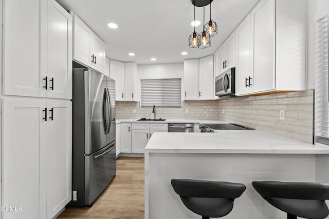 6721 S Springpark Ave Unit 3A, Los Angeles, CA 90056 - kitchen featuring appliances with stainless steel finishes, a sink, a peninsula, white cabinets, and recessed lighting