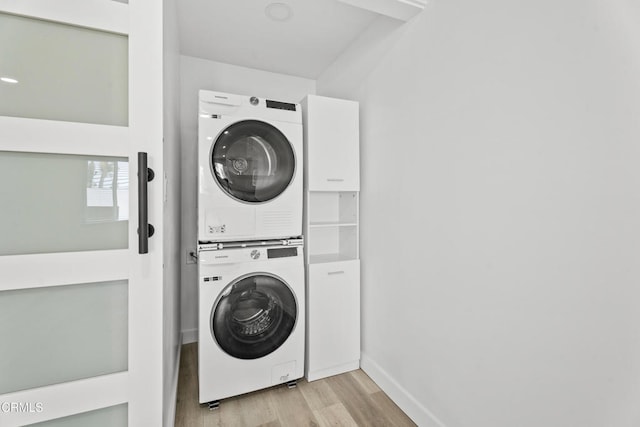 6721 S Springpark Ave Unit 3A, Los Angeles, CA 90056 - laundry area with estacked washer and dryer, light wood-style floors, and baseboards