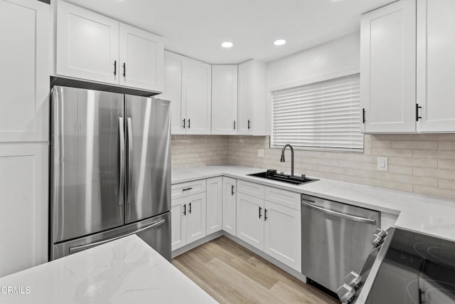 6721 S Springpark Ave Unit 3A, Los Angeles, CA 90056 - kitchen with stainless steel appliances, a sink, white cabinetry, light stone counters, and recessed lighting