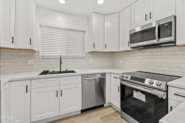 6721 S Springpark Ave Unit 3A, Los Angeles, CA 90056 - kitchen featuring appliances with stainless steel finishes, a sink, white cabinetry, backsplash, and recessed lighting