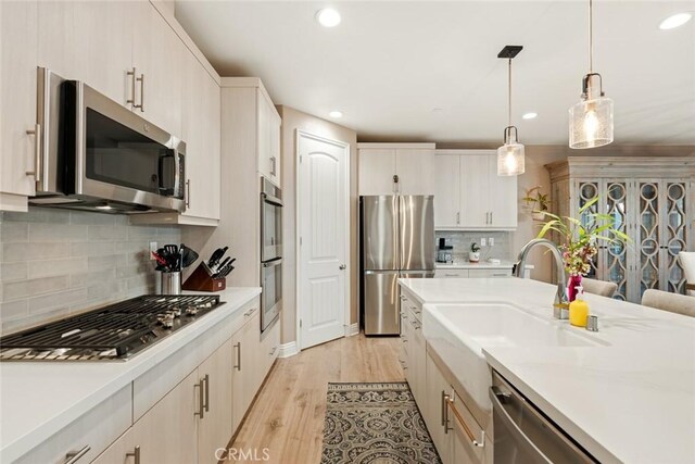 32106 Richardson St, Menifee, CA 92584 - kitchen featuring appliances with stainless steel finishes, a sink, light countertops, recessed lighting, and backsplash
