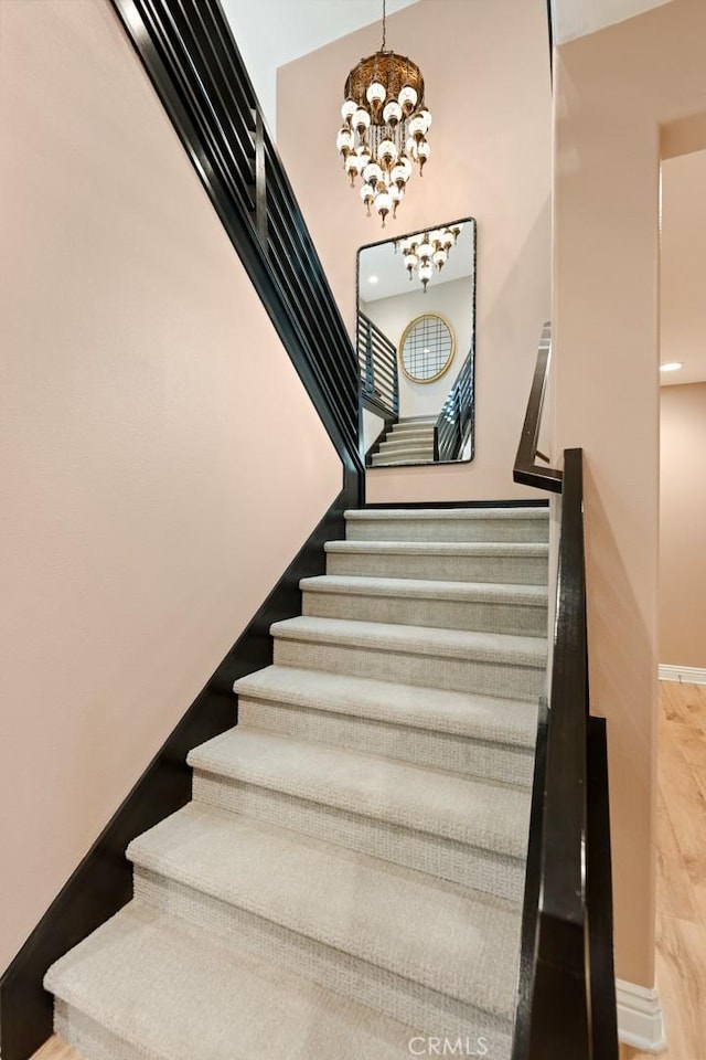 32106 Richardson St, Menifee, CA 92584 - staircase featuring a chandelier, wood finished floors, and baseboards