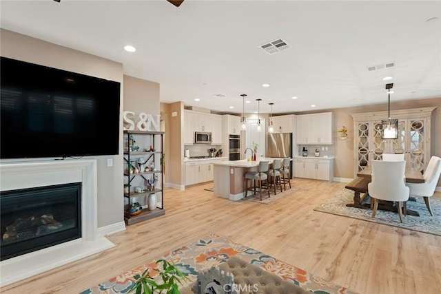 32106 Richardson St, Menifee, CA 92584 - living room with light wood finished floors, baseboards, a glass covered fireplace, and recessed lighting