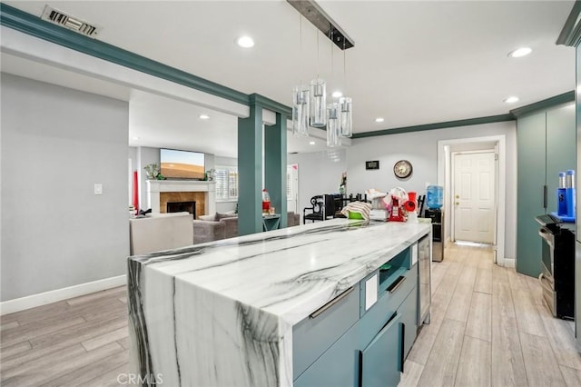 3336 Cherokee Ave, South Gate, CA 90280 - kitchen with light wood-style floors, recessed lighting, a fireplace, stainless steel range with electric cooktop, and light stone countertops