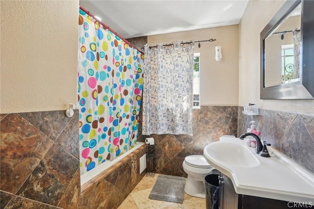 3336 Cherokee Ave, South Gate, CA 90280 - bathroom featuring tile walls, toilet, tiled shower / bath combo, vanity, and a wainscoted wall