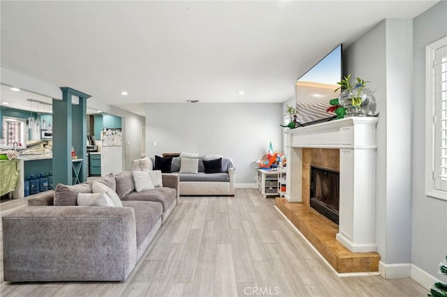 3336 Cherokee Ave, South Gate, CA 90280 - living room with light wood-style flooring, a tile fireplace, baseboards, and recessed lighting
