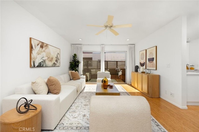 living area with light wood-style floors, ceiling fan, baseboards, and recessed lighting