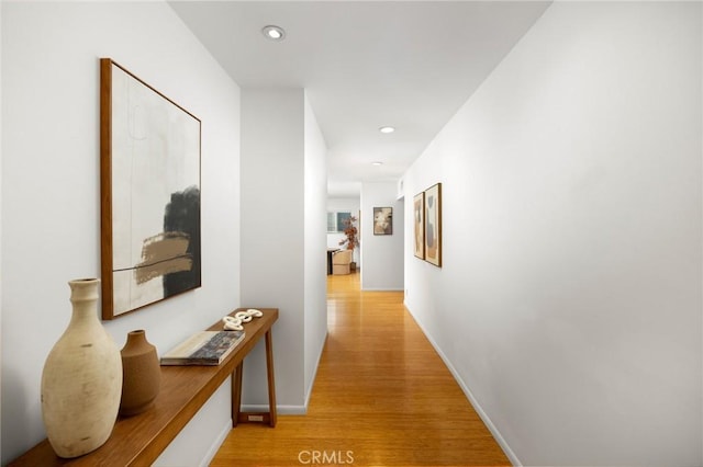 hall with light wood finished floors, recessed lighting, and baseboards