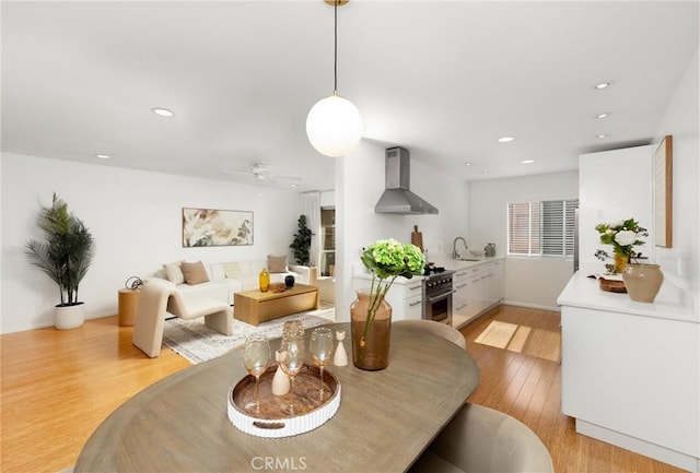 dining room featuring light wood-type flooring, ceiling fan, and recessed lighting