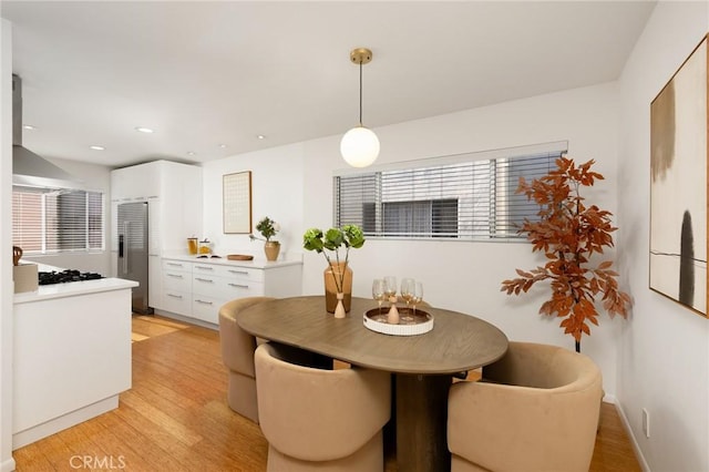 dining space with light wood-style floors and recessed lighting