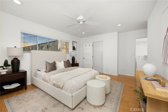 bedroom with light wood-style floors, recessed lighting, a walk in closet, baseboards, and ceiling fan