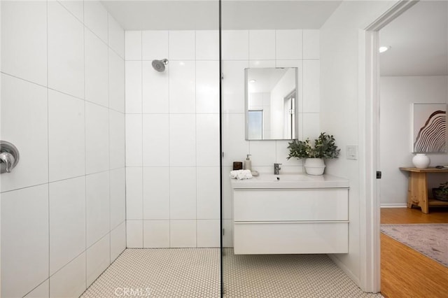 bathroom featuring a walk in shower and vanity