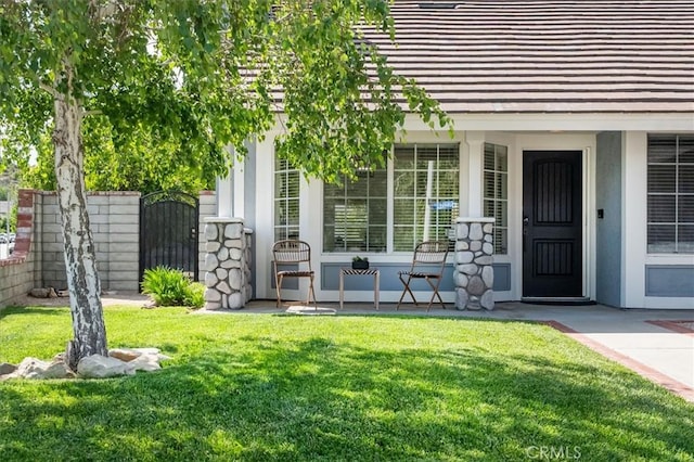 entrance to property with covered porch and a gate