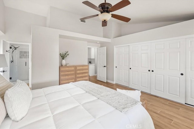 bedroom with light wood finished floors, a closet, high vaulted ceiling, and a ceiling fan