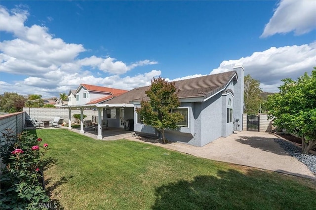 rear view of house featuring a gate, stucco siding, a chimney, a patio area, and a tile roof