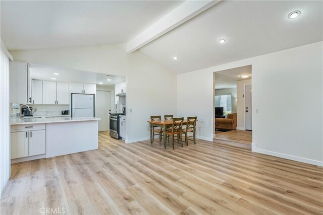 16230 Rodeo St, Hesperia, CA 92345 - kitchen featuring freestanding refrigerator, stainless steel gas range, a sink, light countertops, and a peninsula