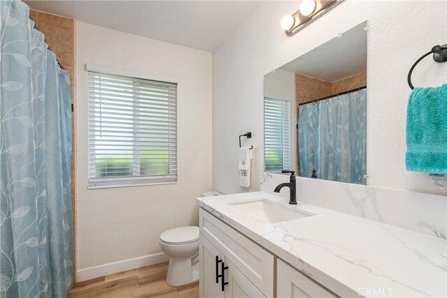 16230 Rodeo St, Hesperia, CA 92345 - full bath featuring wood finished floors, vanity, baseboards, toilet, and a shower with curtain
