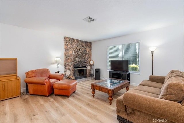 16230 Rodeo St, Hesperia, CA 92345 - living room featuring light wood-style floors, a stone fireplace, and baseboards