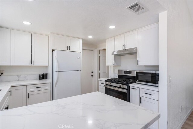 16230 Rodeo St, Hesperia, CA 92345 - kitchen with stainless steel appliances, under cabinet range hood, white cabinetry, light stone counters, and recessed lighting