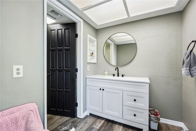 bathroom with wood finished floors, vanity, and baseboards